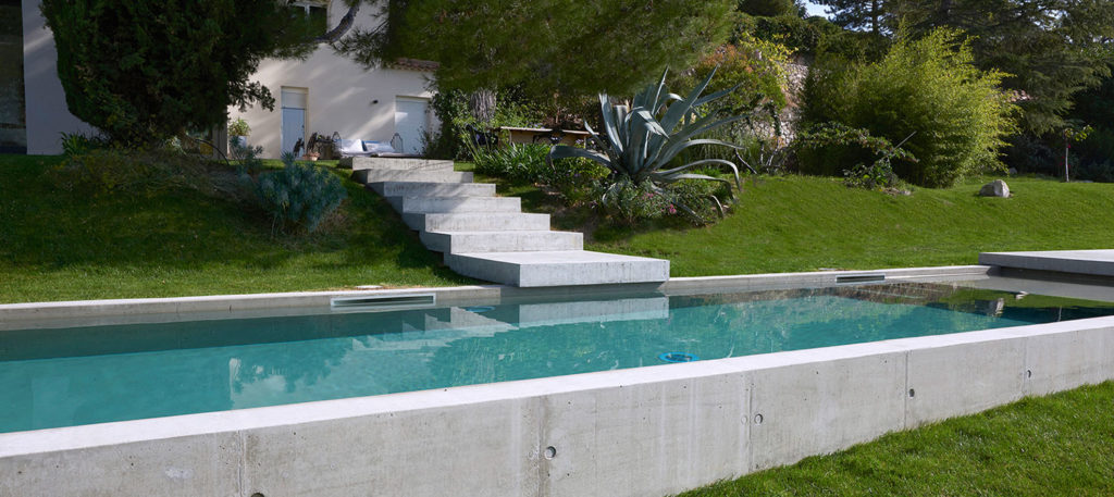 piscine en béton brut semi-enterrée