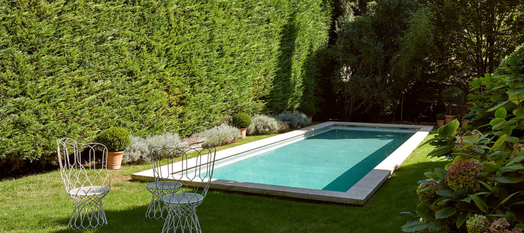 piscine béton brut dans un jardin clos