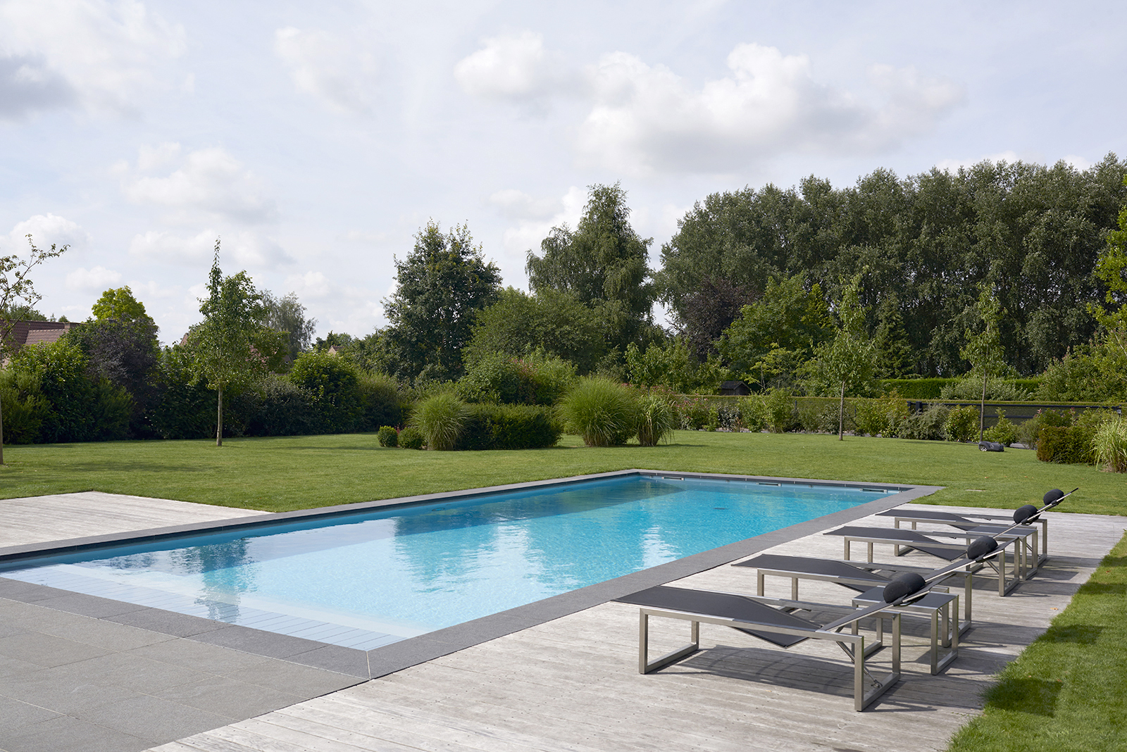 piscine rectangulaire dans un jardin arboré