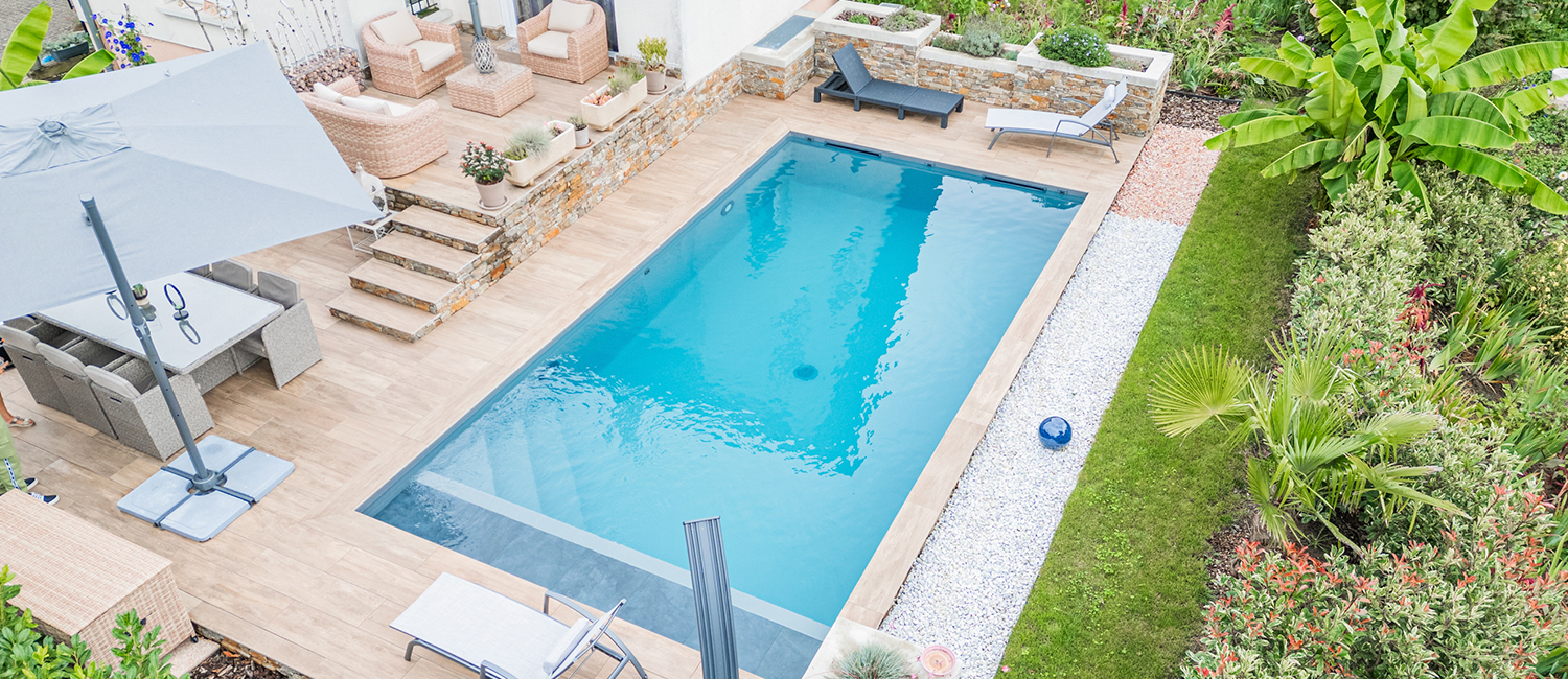 Une piscine traditionnelle au cœur d’un jardin luxuriant