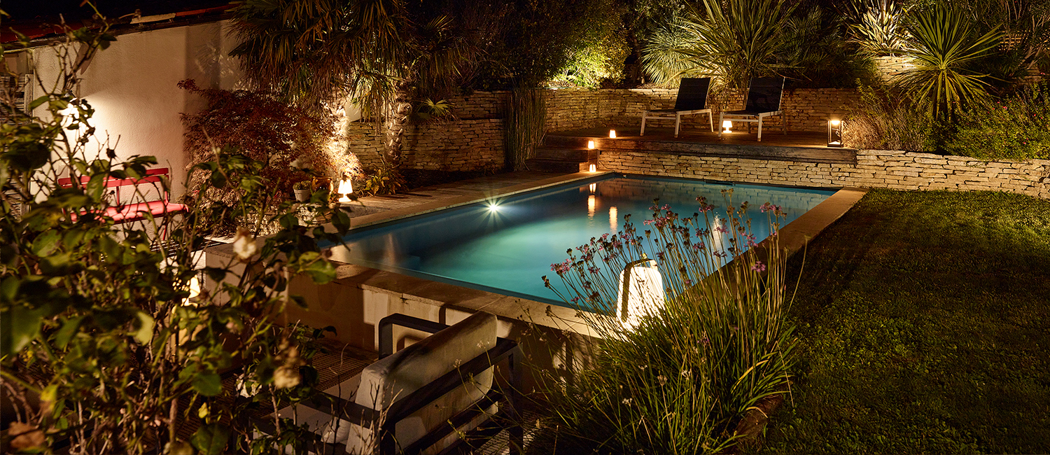Mobilier tendance éclairage doux autour d’une petite piscine
