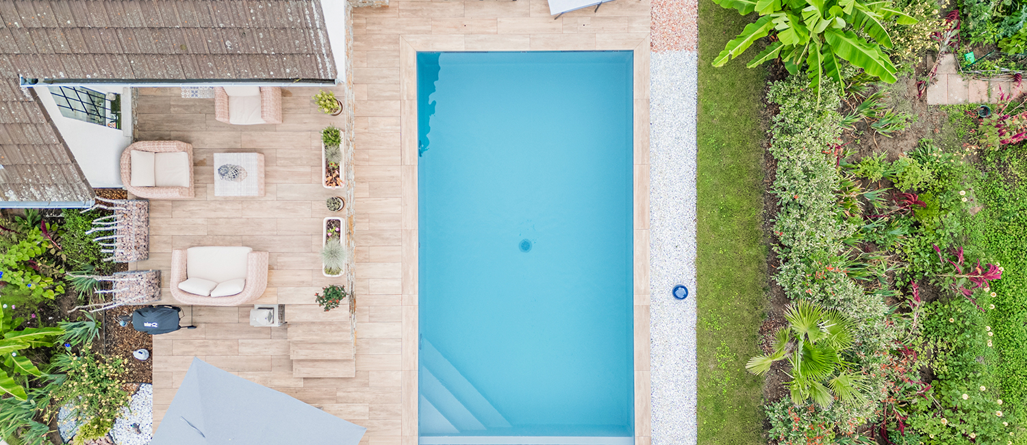 Une piscine traditionnelle au cœur d’un jardin luxuriant