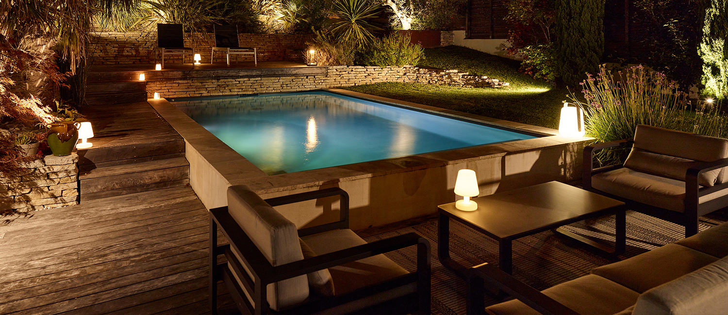 Mobilier tendance éclairage doux autour d’une petite piscine