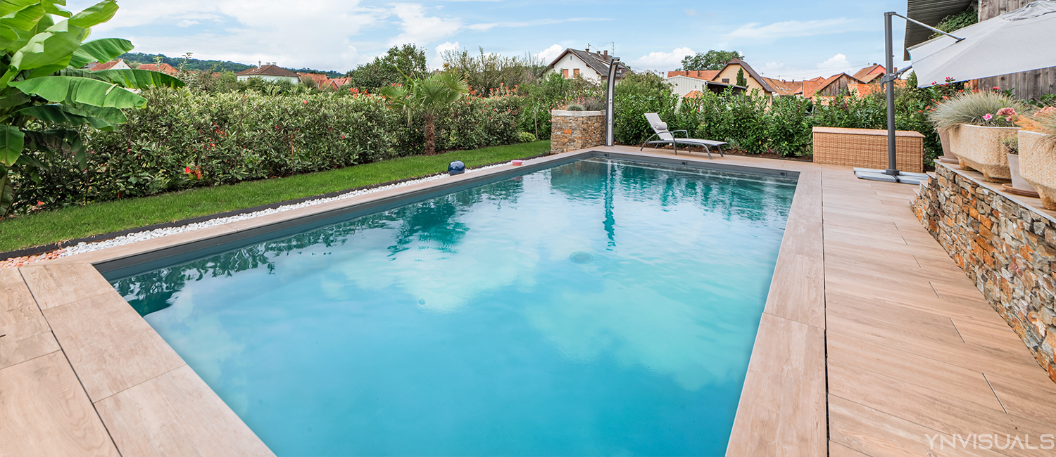 Une piscine traditionnelle au cœur d’un jardin luxuriant