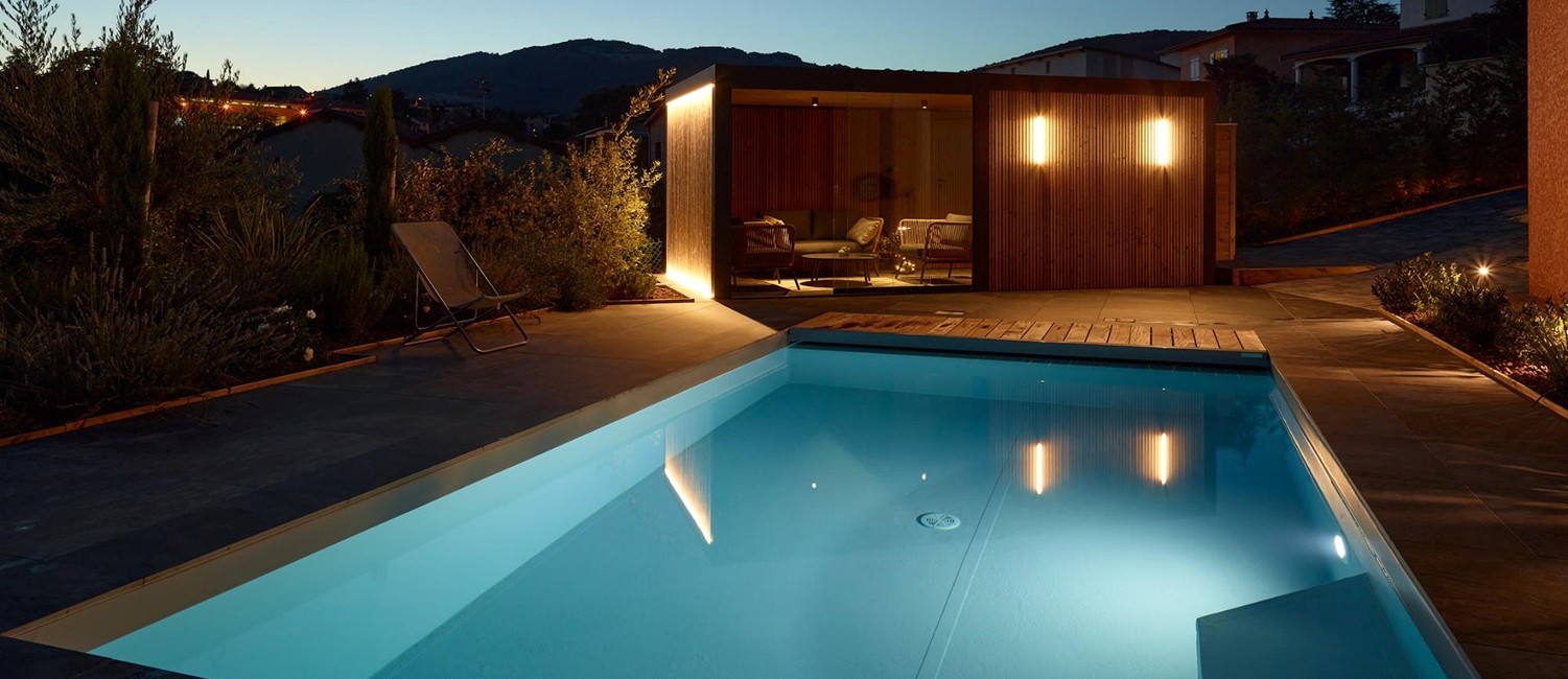 Petite piscine paysagée de nuit et pool house design