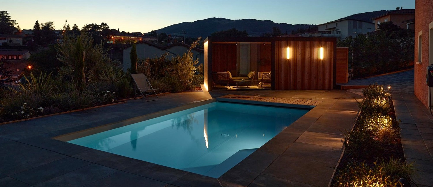 Petite piscine paysagée de nuit et pool house design