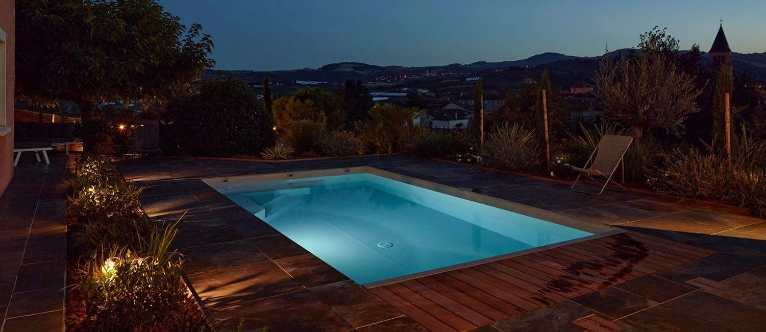Petite piscine paysagée de nuit et pool house design