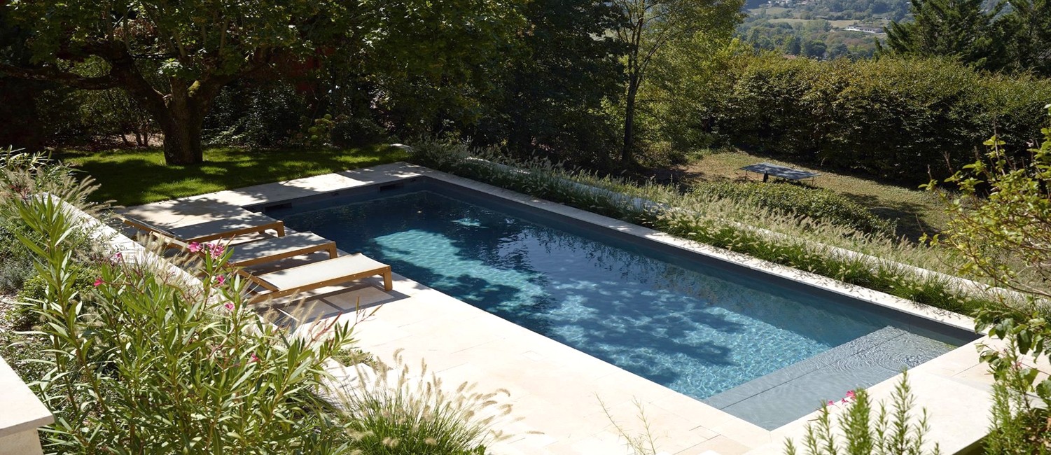 Une piscine en terrasse au cœur d’un parc arboré