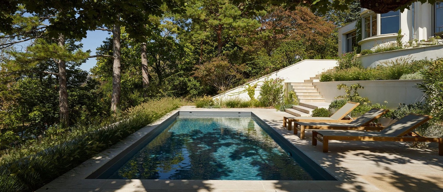 Une piscine en terrasse au cœur d’un parc arboré