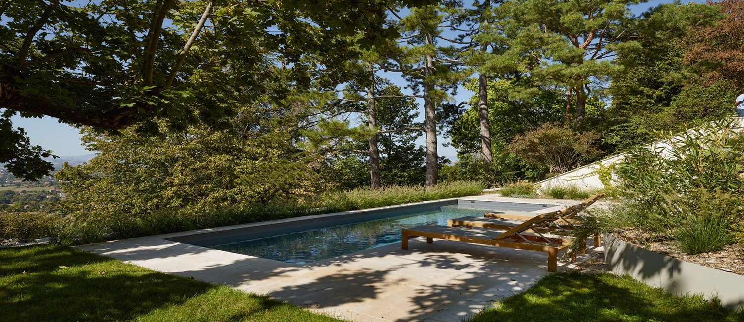 Une piscine en terrasse au cœur d’un parc arboré