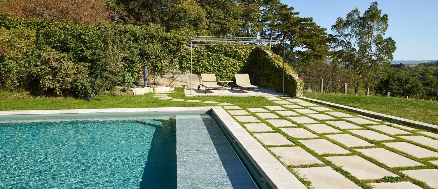 Piscine carrée au cœur d’un jardin graphique