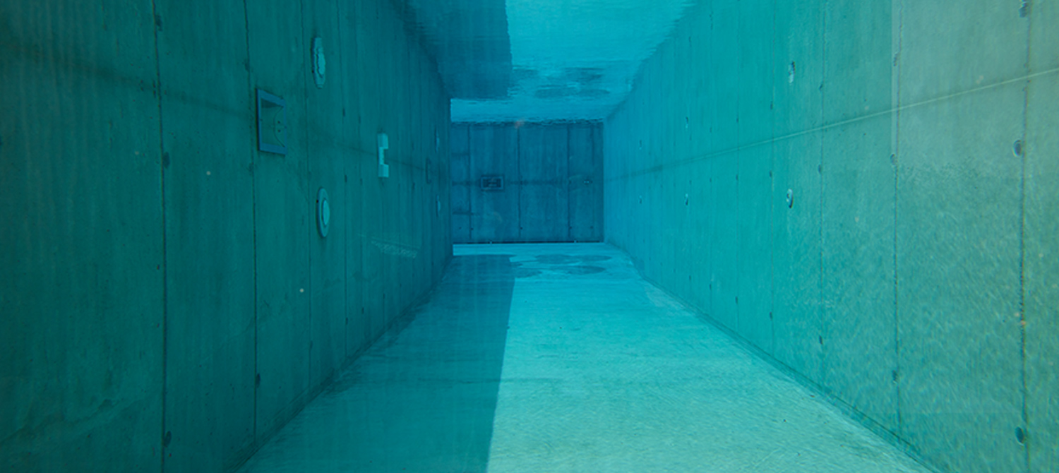 Couloir de nage en béton brut avec paroi de verre